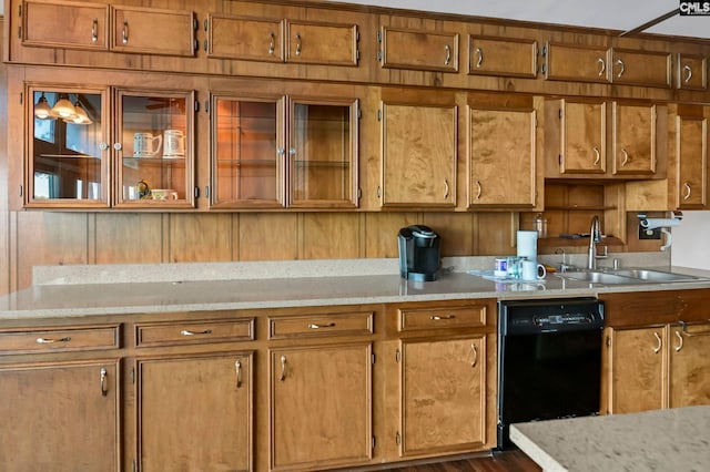 kitchen with dishwasher, sink, and light stone counters