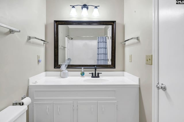 bathroom featuring vanity, toilet, and curtained shower