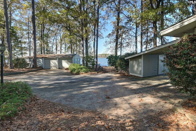 exterior space with a garage, an outdoor structure, and a water view