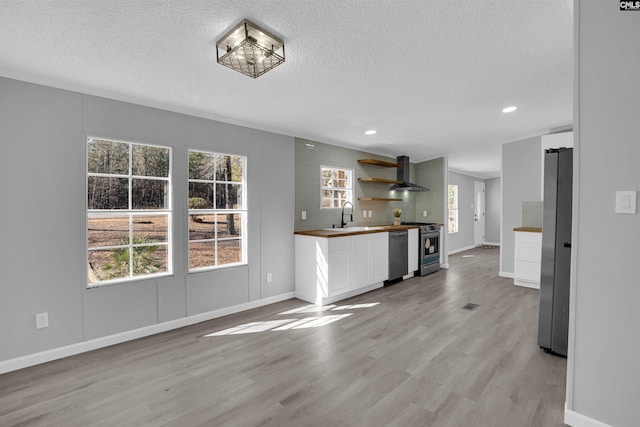 unfurnished living room with sink, a textured ceiling, and light hardwood / wood-style floors