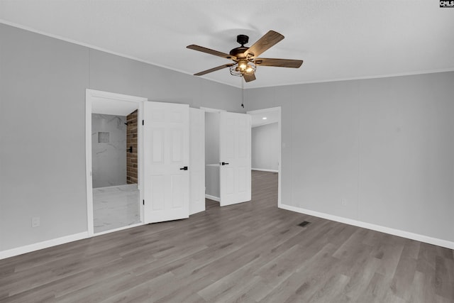 unfurnished bedroom featuring ensuite bath, ornamental molding, and light hardwood / wood-style flooring