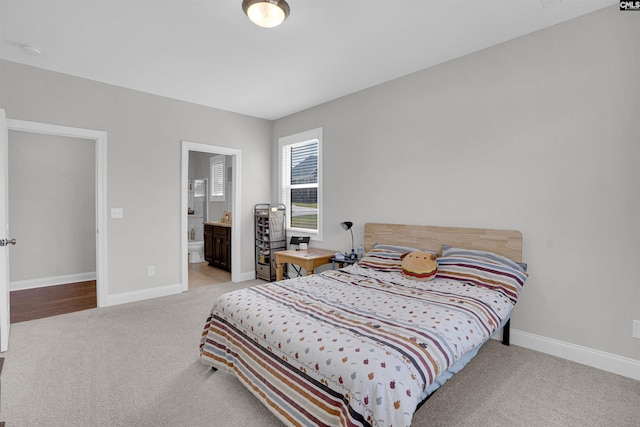 carpeted bedroom featuring ensuite bath