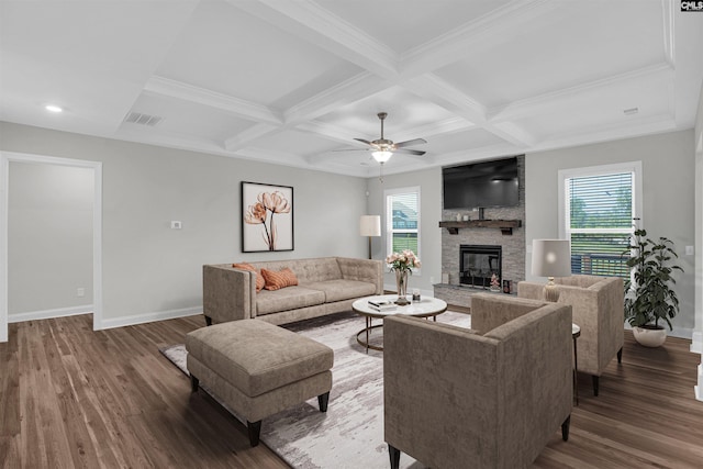 living room featuring a stone fireplace, beamed ceiling, coffered ceiling, ceiling fan, and dark wood-type flooring