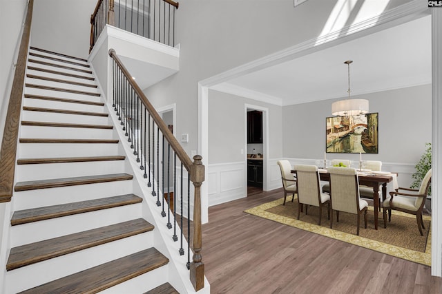 dining area with crown molding, dark wood-type flooring, and a high ceiling