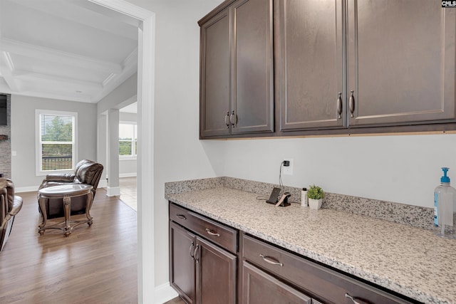 kitchen featuring coffered ceiling, light stone countertops, light hardwood / wood-style floors, and dark brown cabinets