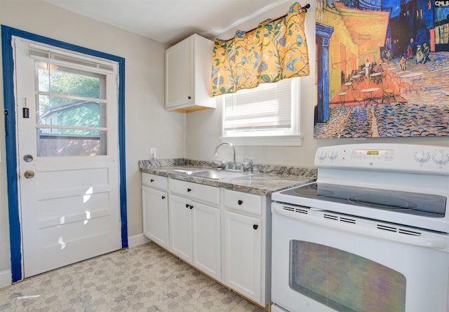 kitchen featuring light stone counters, sink, electric range, and white cabinets