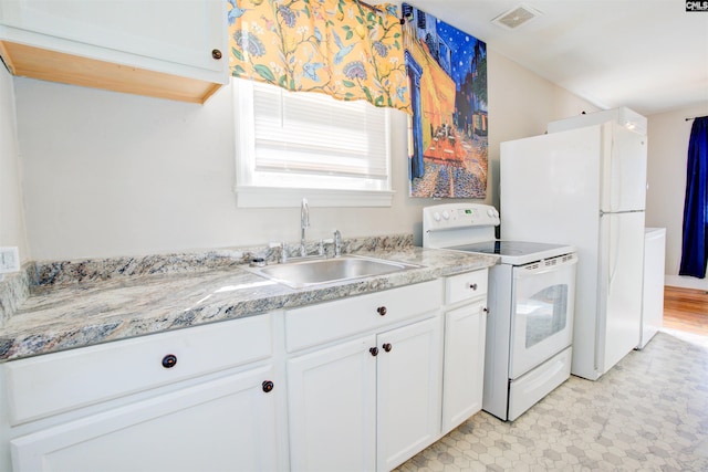 kitchen with white cabinetry, sink, light stone counters, and white appliances