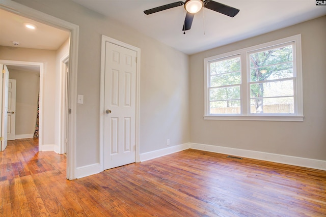 unfurnished bedroom with ceiling fan, wood-type flooring, and a closet