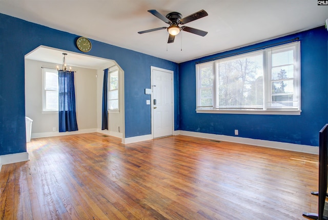 interior space featuring hardwood / wood-style flooring and ceiling fan with notable chandelier