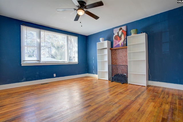 interior space with hardwood / wood-style flooring, ceiling fan, and a fireplace