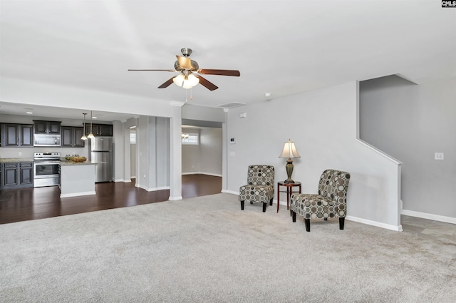 living area featuring ceiling fan and dark carpet