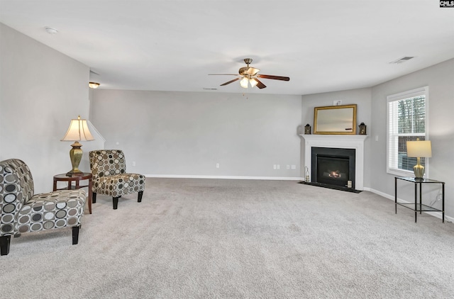 sitting room with ceiling fan and carpet floors