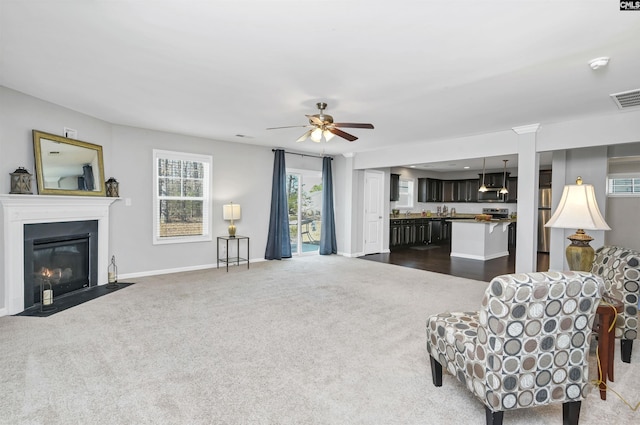 carpeted living room with ceiling fan