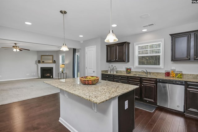 kitchen featuring dark brown cabinetry, decorative light fixtures, a kitchen breakfast bar, dishwasher, and a kitchen island