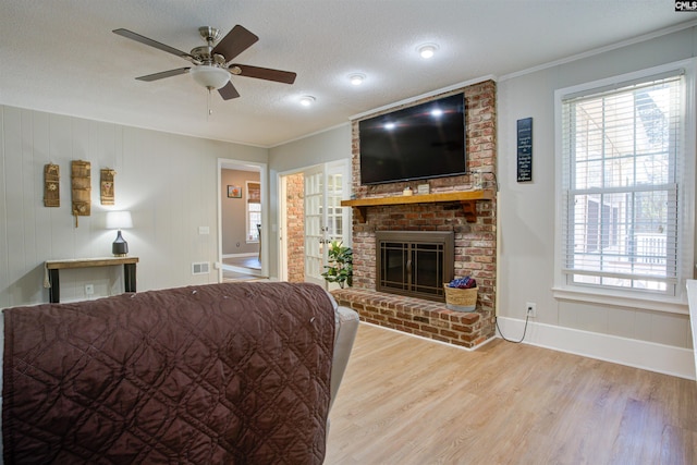 living room featuring hardwood / wood-style flooring, a healthy amount of sunlight, a textured ceiling, and a fireplace