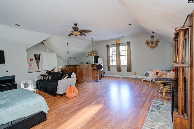 bedroom with lofted ceiling, hardwood / wood-style floors, and stainless steel fridge with ice dispenser