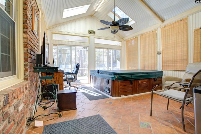 sunroom featuring ceiling fan and vaulted ceiling with skylight