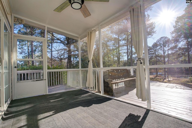 unfurnished sunroom featuring ceiling fan and a wealth of natural light