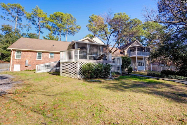 back of house with a sunroom and a yard