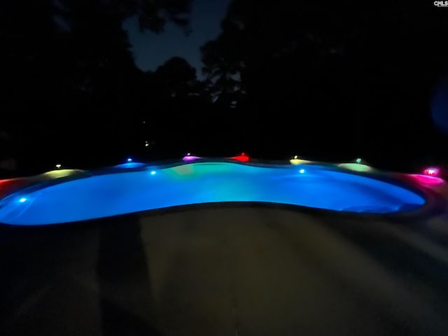 view of pool at twilight