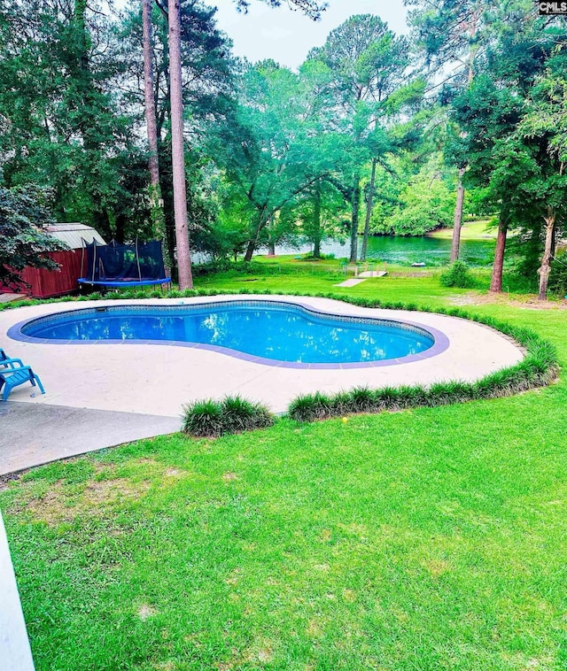 view of swimming pool with a yard and a trampoline