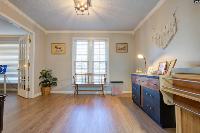 misc room with ornamental molding, a textured ceiling, and light hardwood / wood-style floors