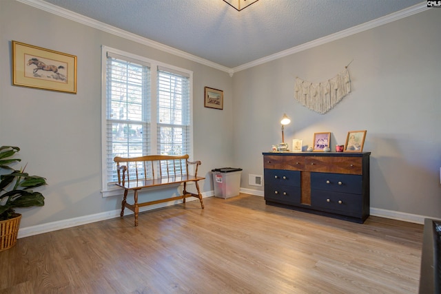 sitting room with ornamental molding, a textured ceiling, and light hardwood / wood-style floors