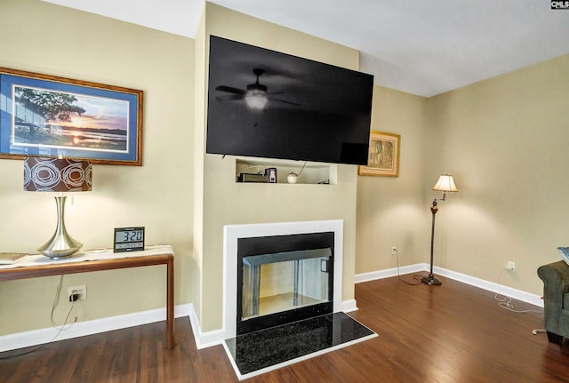 living room with dark hardwood / wood-style floors, ceiling fan, and a multi sided fireplace