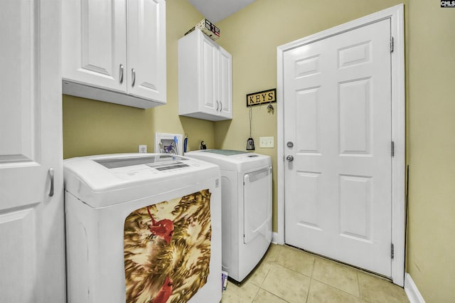 laundry room with cabinets, washing machine and dryer, and light tile patterned floors