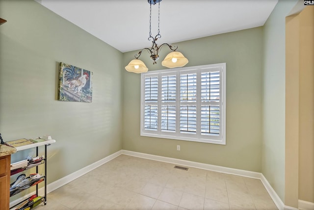 spare room with a notable chandelier