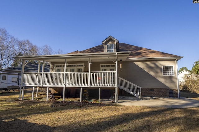 back of house featuring covered porch, a patio area, and a lawn