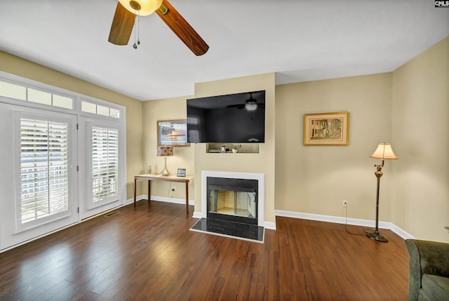 living room featuring dark wood-type flooring and ceiling fan