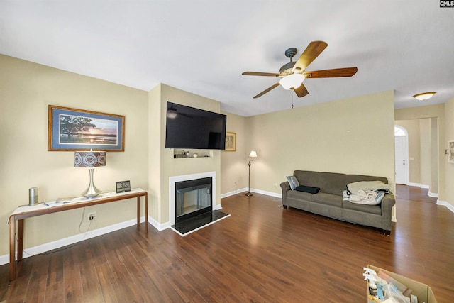 living room featuring dark wood-type flooring and ceiling fan