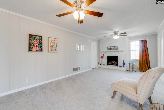 sitting room featuring a brick fireplace, ornamental molding, light colored carpet, and ceiling fan