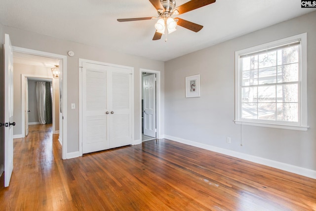 unfurnished bedroom featuring a closet, dark hardwood / wood-style floors, and ceiling fan