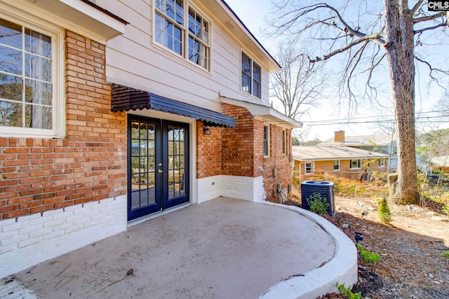 view of exterior entry featuring central AC and french doors