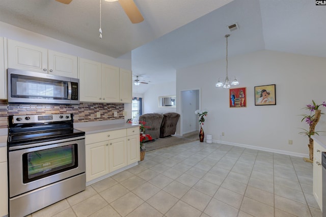 kitchen featuring vaulted ceiling, appliances with stainless steel finishes, pendant lighting, ceiling fan, and backsplash