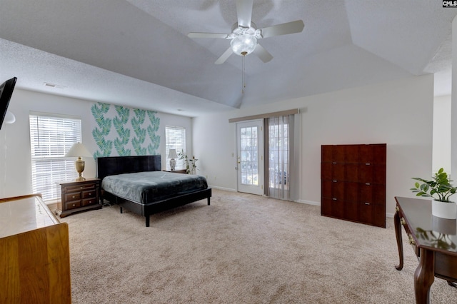 bedroom featuring multiple windows, vaulted ceiling, light carpet, and a textured ceiling