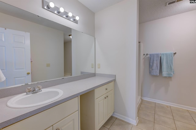 bathroom featuring walk in shower, tile patterned floors, and vanity