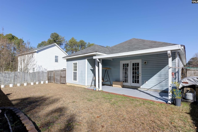 rear view of property with a patio, a yard, and french doors