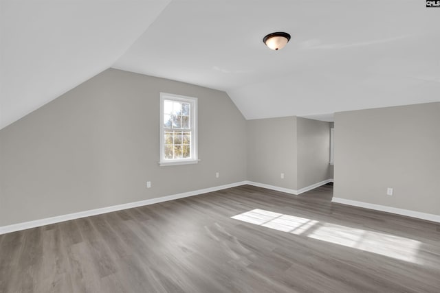 bonus room featuring lofted ceiling and dark hardwood / wood-style floors