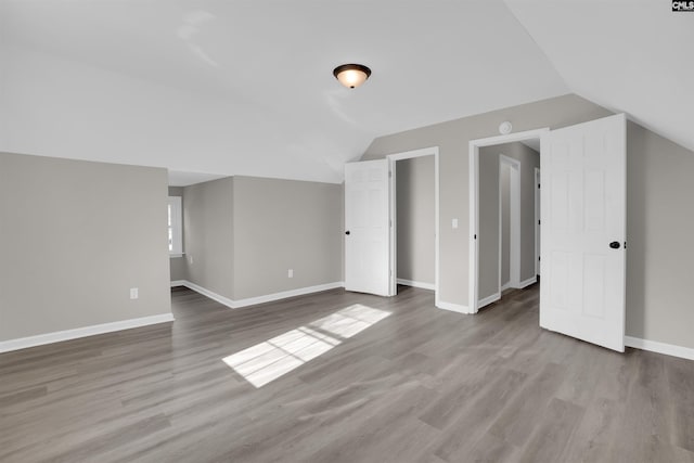 additional living space with lofted ceiling and light hardwood / wood-style flooring