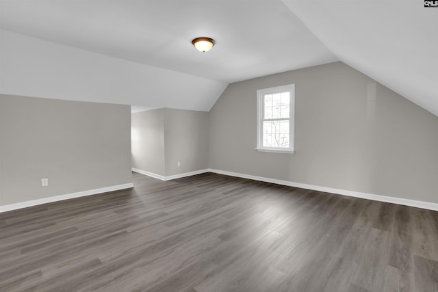 bonus room with dark hardwood / wood-style flooring and vaulted ceiling