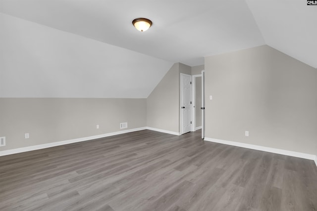 additional living space featuring hardwood / wood-style flooring and lofted ceiling