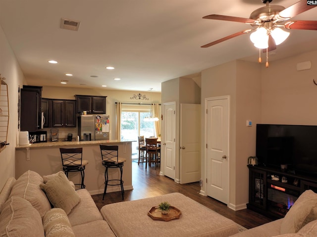 living room featuring visible vents, a ceiling fan, dark wood finished floors, recessed lighting, and baseboards