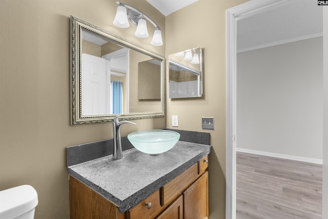 bathroom featuring vanity, wood-type flooring, and toilet