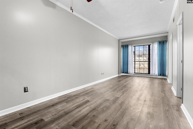 unfurnished room featuring ceiling fan, ornamental molding, wood-type flooring, and a textured ceiling