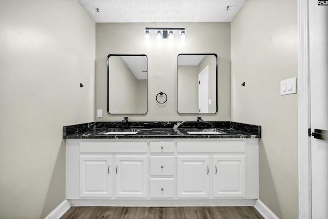 bathroom with vanity, wood-type flooring, and a textured ceiling