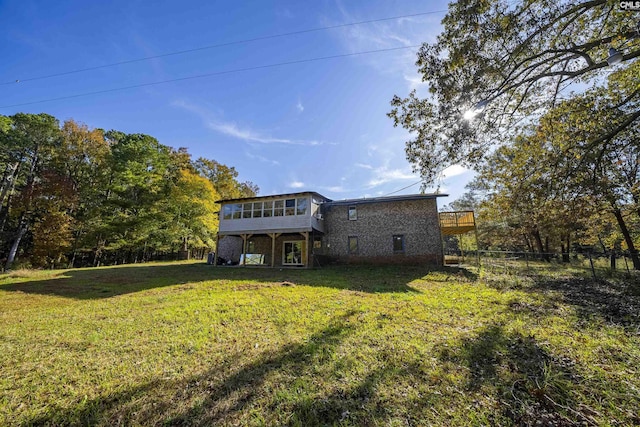 rear view of house with a sunroom and a lawn