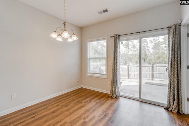 unfurnished room with wood-type flooring and a chandelier